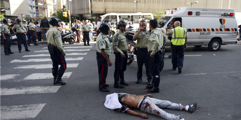 Police stand by a man murdered in one of